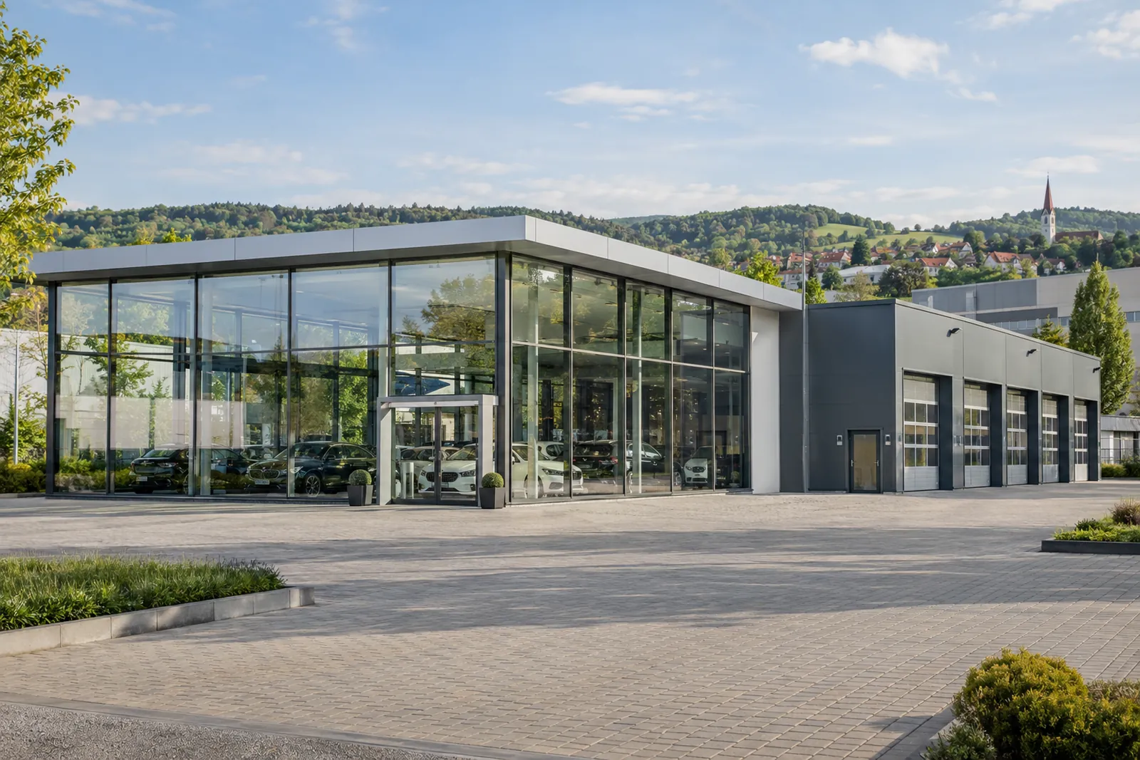 Autohaus mit Glasfront und Werkstattanbau in einem Gewerbegebiet bei Sindelfingen vor grünen Hügeln