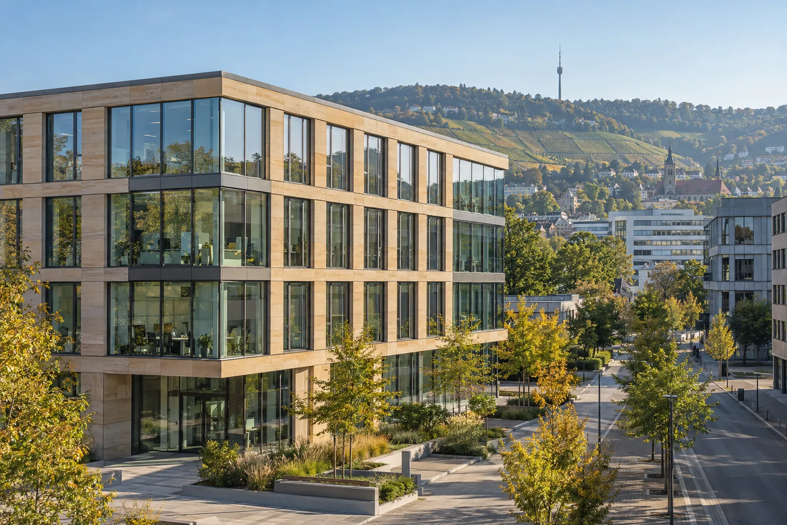 Moderner Bürobau mit Glas- und Sandsteinfassade in Stuttgart, dahinter Weinberghänge am Neckar