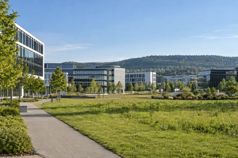 Moderne Büro- und Gewerbebauten im Gebiet des Flugfelds Böblingen vor bewaldeten Hügeln