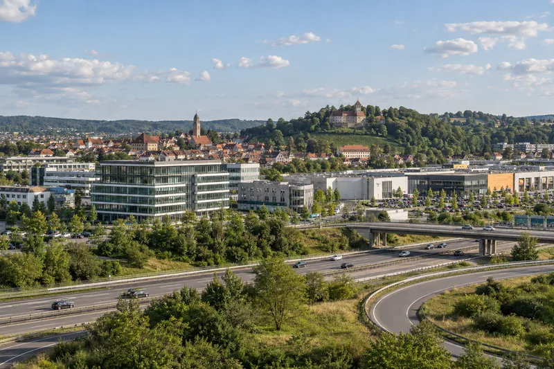 Gewerbebauten in Leonberg mit Bürogebäude und Einkaufszentrum, im Hintergrund die Dächer der Altstadt am Engelberg