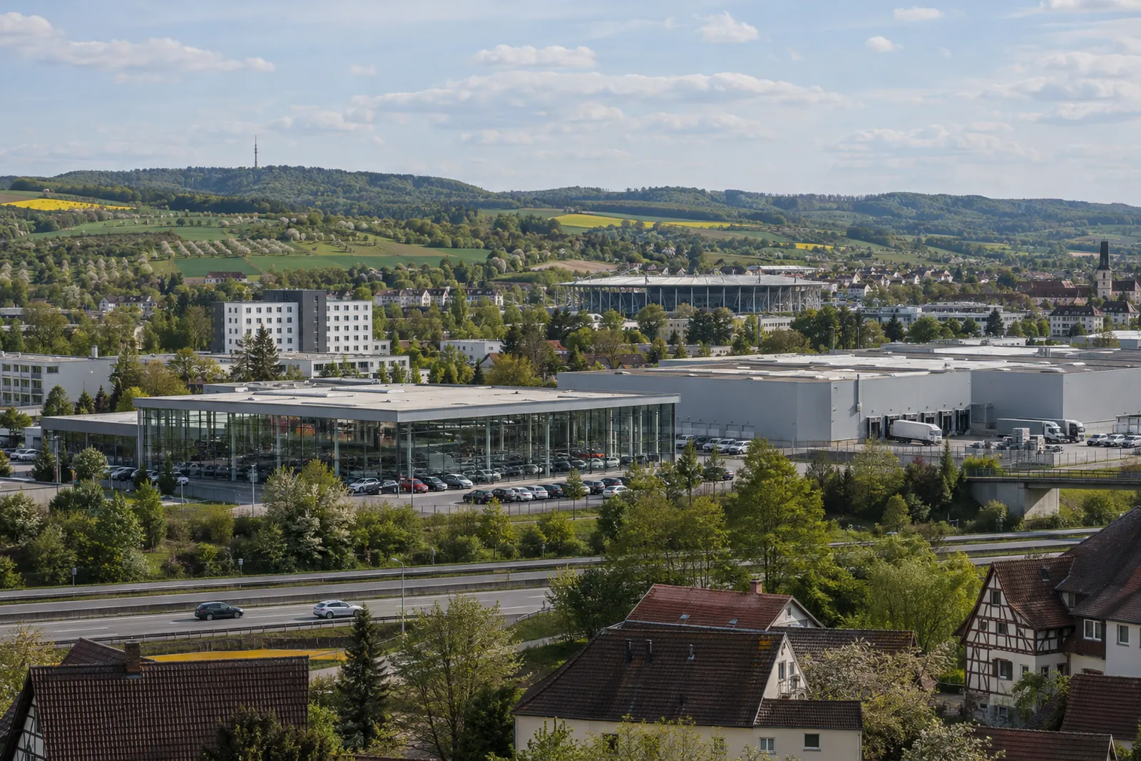 Autohaus und Logistikhalle bei Sinsheim im Kraichgau mit Hotelgebäude und Stadiondach am Horizont