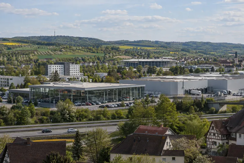 Autohaus und Logistikhalle bei Sinsheim im Kraichgau mit Hotelgebäude und Stadiondach am Horizont