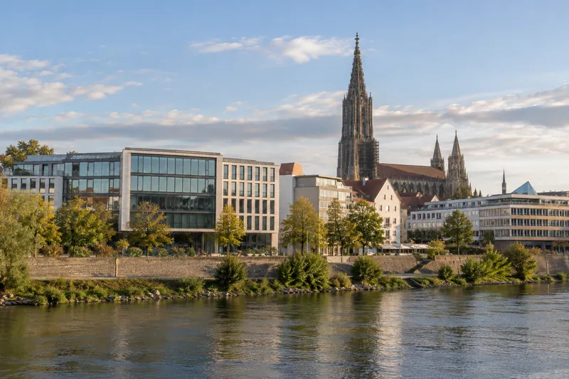 Büro- und Geschäftshäuser in Ulm mit dem Turm des Ulmer Münsters im Hintergrund